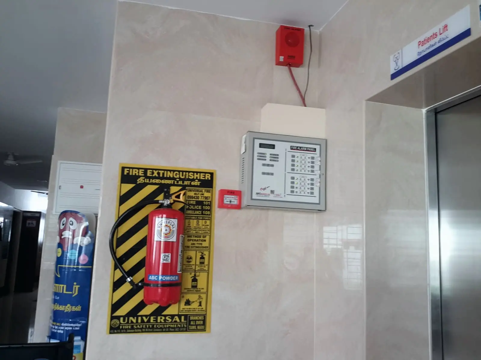 ABC extinguisher on its instruction board beside the fire alarm panel