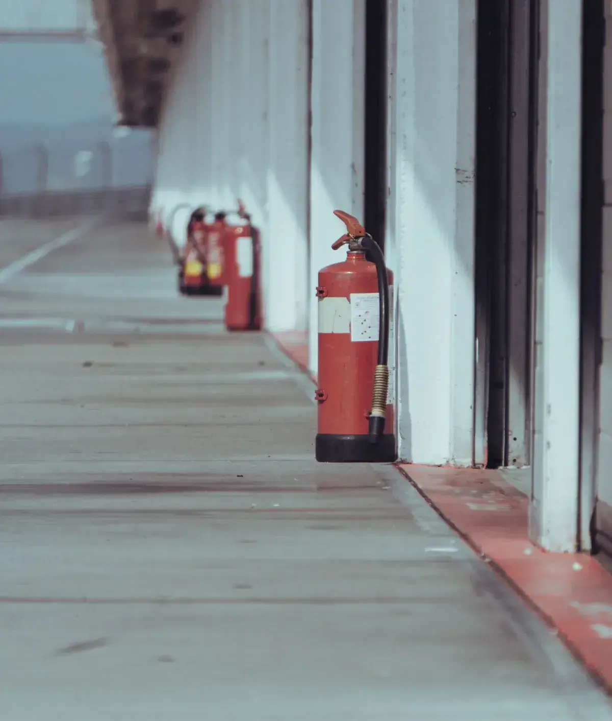Fire extinguishers along a factory walkway