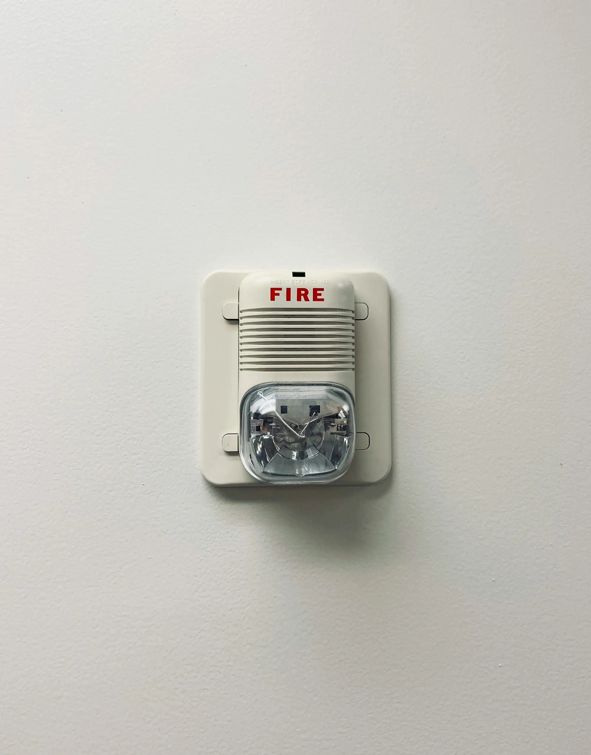 Fire alarm sounder and strobe on a white wall