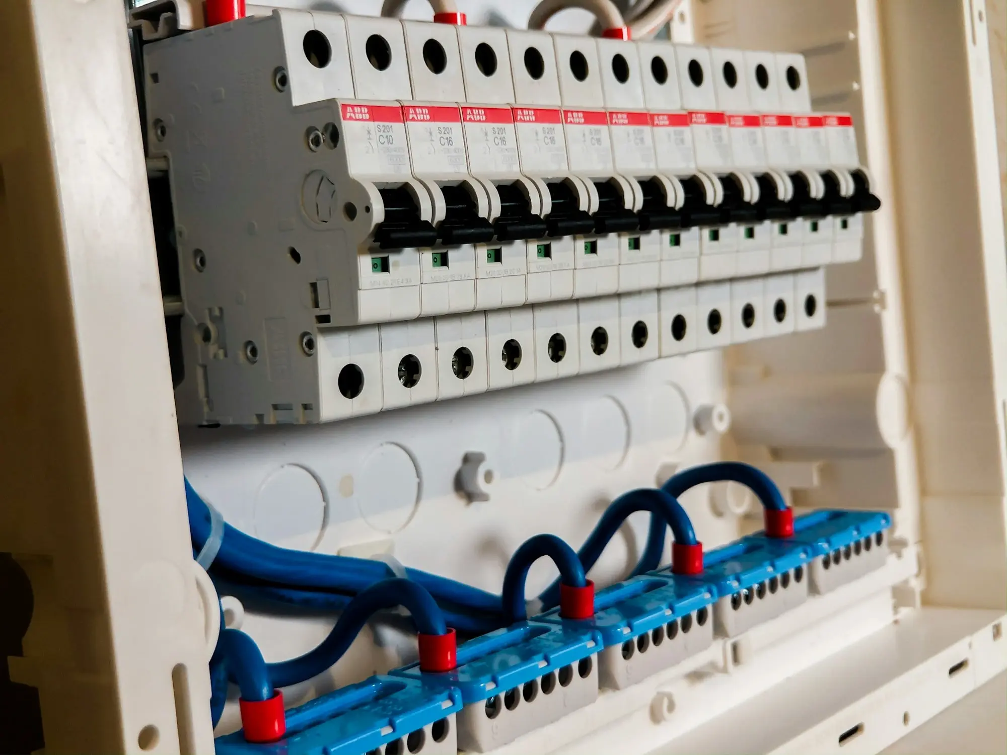 Open electrical panel with rows of circuit breakers