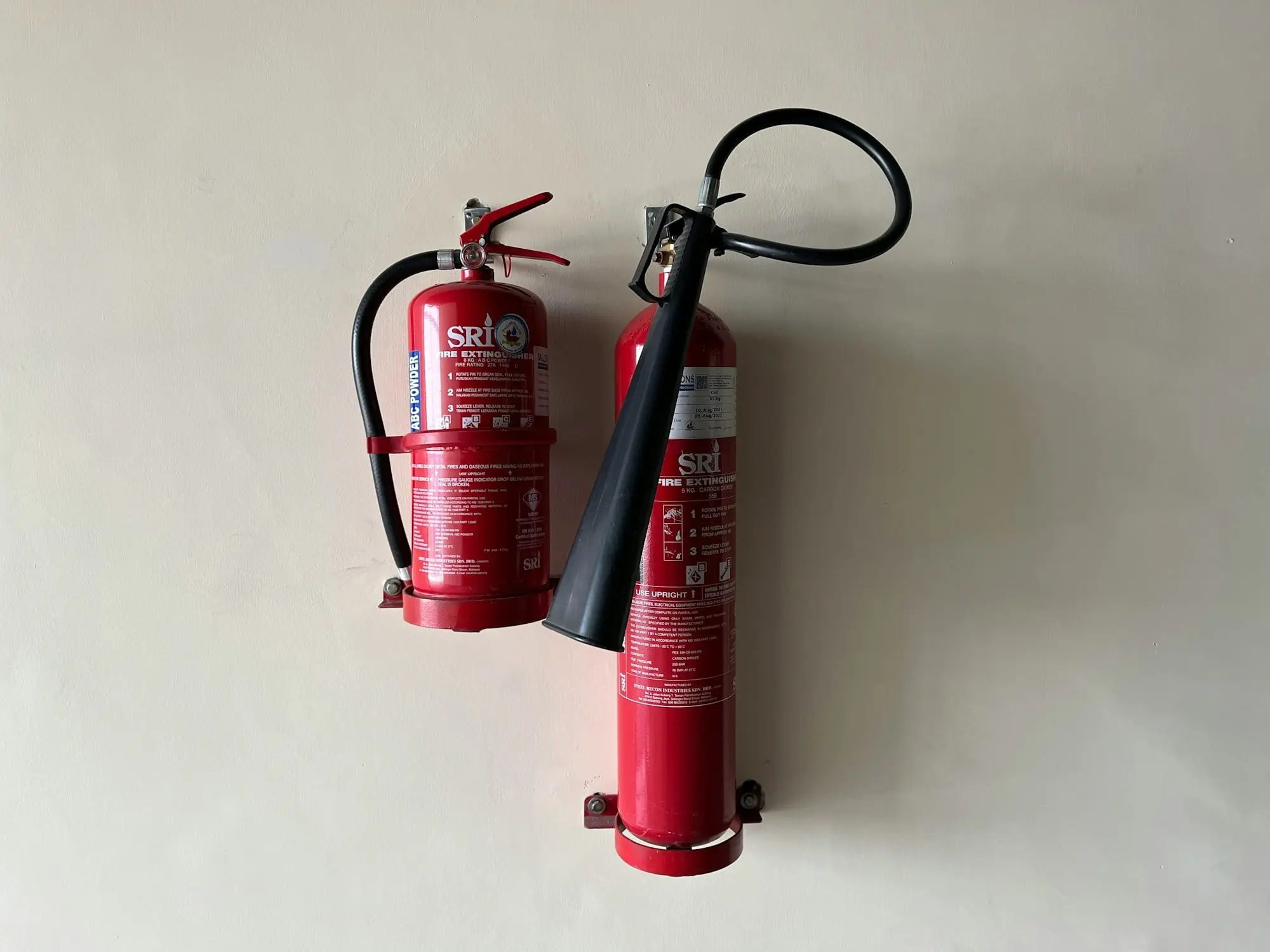 Two red fire extinguishers on a white background